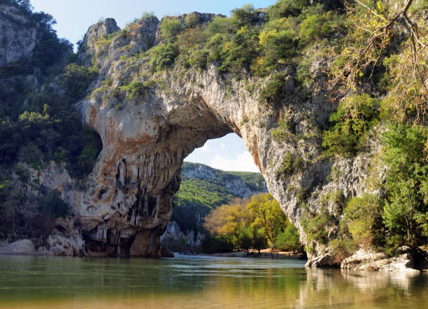 フランスのアルデシュ川に映る峡谷の峡谷のロックアーチ・ポン・ダルク - 山峡 ストックフォトと画像