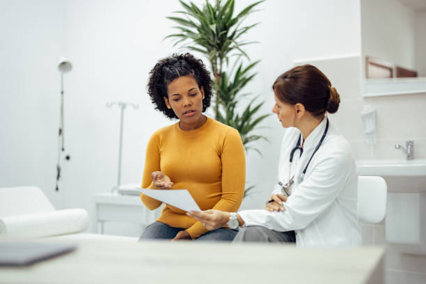 Patient and doctor discussing test results. Female patient and doctor discussing test results in medical office. discussion stock pictures, royalty-free photos & images