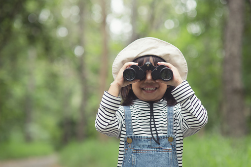 Happy kid looking ahead. Smiling child with the binoculars. Travel and adventure concept. Freedom, vacation