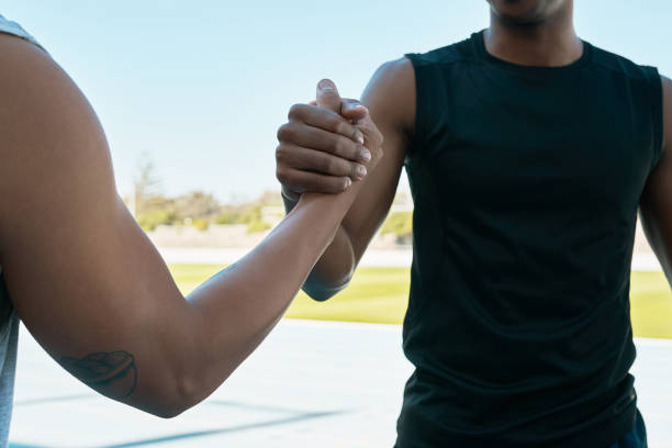 istock Cropped shot of two unrecognisable men shaking hands while out on the track field 1343540141