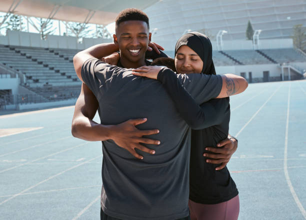 istock Shot of three athletes sharing a hug while out on the track together 1343540190