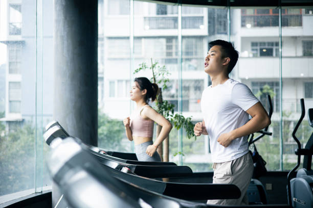 Couple working exercise on treadmill in gym stock photo