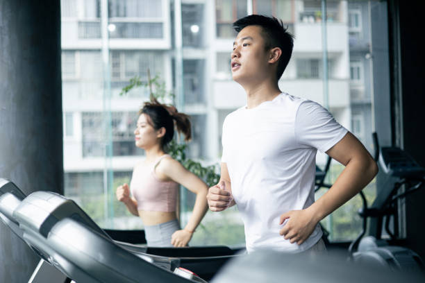 ジムでトレッドミルのカップルの作業運動 - treadmill gym health club exercising ストックフォトと画像