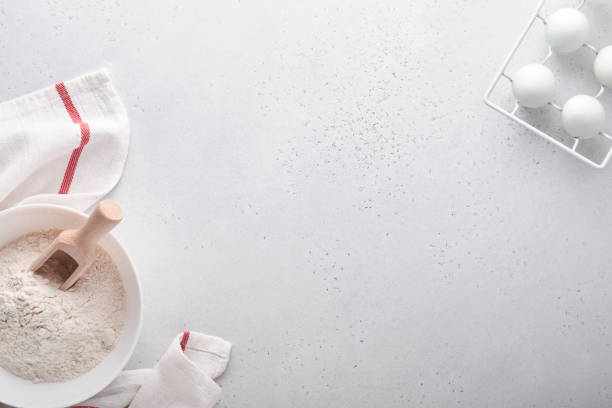 istock Baking background with flour, eggs, kitchen tools, utensils and cookie molds on white marble table. Top view. Flat lay style. Mock up. 1343545745
