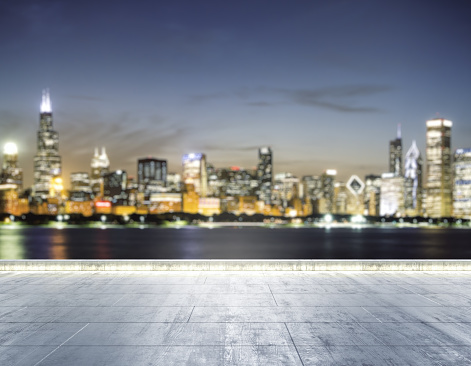Empty concrete dirty embankment on the background of a beautiful blurry Chicago city skyline at night, mockup