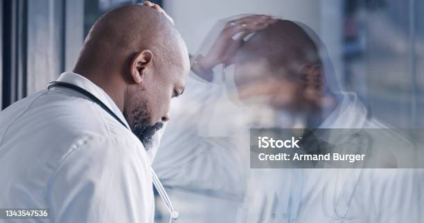 Shot Of A Male Doctor Having A Stressful Day At Work Stock Photo - Download Image Now