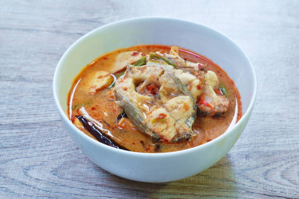 spicy boiled snake head fish meat and slice coconut shoot in tom yum soup stock photo