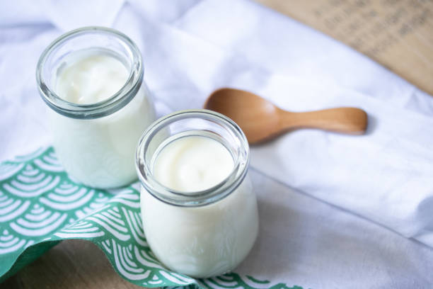 istock white yogurt in two glass jars on green background 1343549072