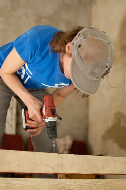 istock Skilled young female worker is using power screwdriver drilling during construction wooden bench gender equality, feminism, do it yourself concepts 1343549613