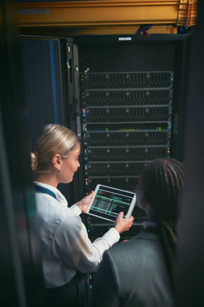 istock Shot of two young IT specialists standing in the server room and having a discussion while using a digital tablet 1343550677