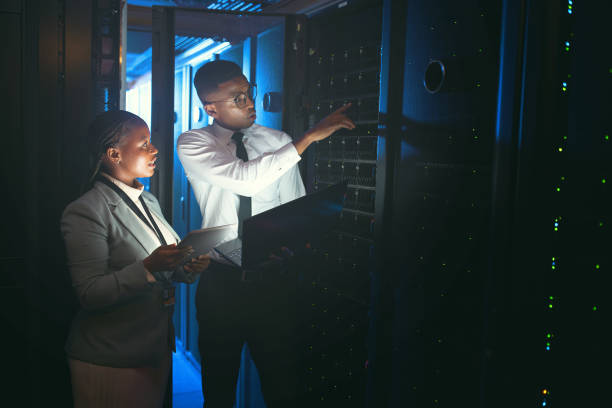 istock Shot of two young IT specialists standing in the server room and having a discussion while using a technology 1343550698