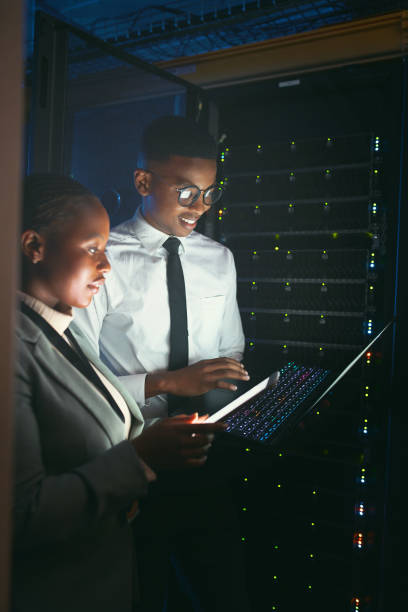 istock Shot of two young IT specialists standing in the server room and having a discussion while using a technology 1343550699