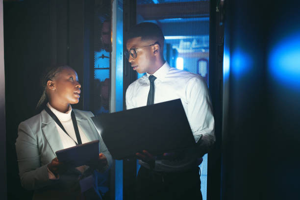 istock Shot of two young IT specialists standing in the server room and having a discussion while using a technology 1343550708