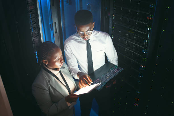istock Shot of two young IT specialists standing in the server room and having a discussion while using a technology 1343550710