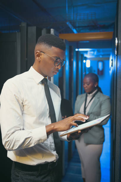 istock Shot of two young IT specialists standing together in the server room and using technology 1343550729
