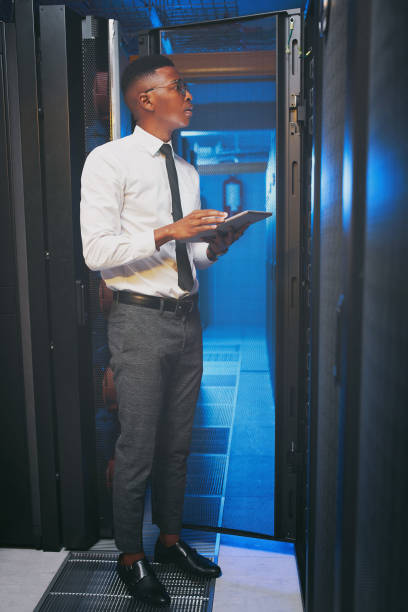 istock Full length shot of a young IT specialist standing alone in the server room and using a digital tablet 1343550747