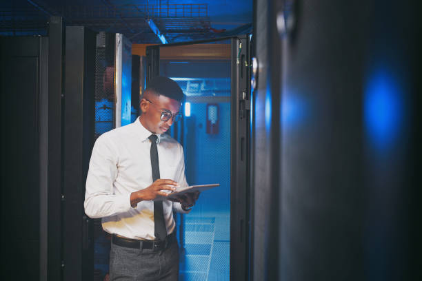 istock Shot of a young IT specialist standing alone in the server room and using a digital tablet 1343550752