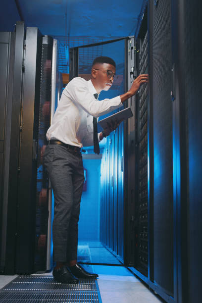 istock Full length shot of a young IT specialist standing alone in the server room and using a digital tablet 1343550764