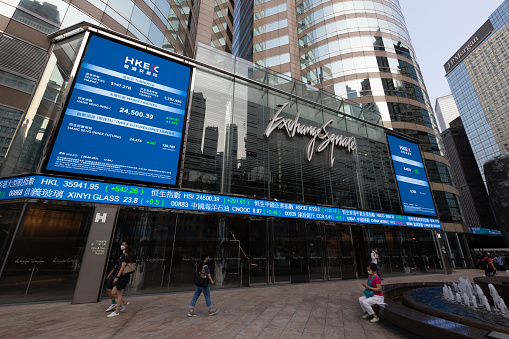 Hong Kong - September 28, 2021 : People walk past the Exchange Square complex, which houses the Hong Kong Stock Exchange (HKEX) in Central, Hong Kong.