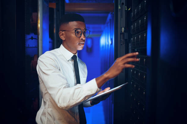 istock Shot of a young man using a digital tablet while working in a server room 1343553188