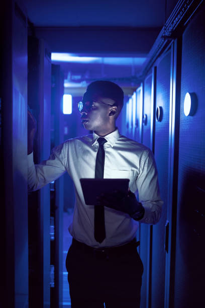 istock Shot of a young man using a digital tablet while working in a server room 1343553194