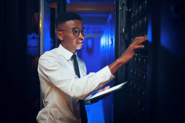 istock Shot of a young man using a digital tablet while working in a server room 1343553197
