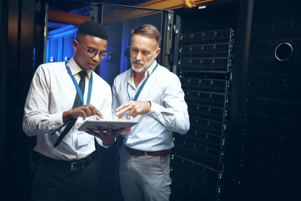 Shot of two technicians using a digital tablet while working in a server room Doing their daily inspections data center stock pictures, royalty-free photos & images