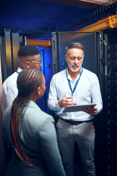 istock Shot of a group of technicians using a digital tablet while working together in a server room 1343553392