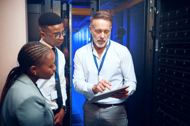 istock Shot of a group of technicians using a digital tablet while working together in a server room 1343553398