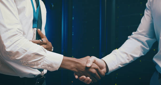 istock Closeup shot of two unrecognisable men shaking hands in a server room 1343554106