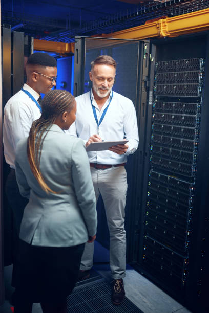 istock Shot of a group of technicians using a digital tablet while working together in a server room 1343554112