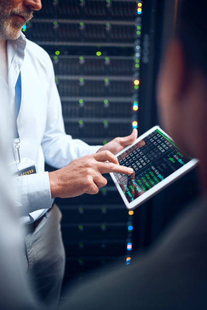istock Closeup shot of an unrecognisable man using a digital tablet while working with a colleague in a server room 1343554117