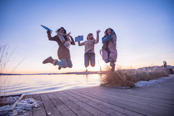 istock Young female students having fun jumping by the river 1343555309