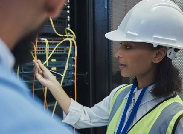 istock Shot of two workers inspecting the electronic equipment in a server room together at work 1343555588