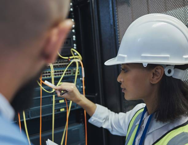 istock Shot of two workers inspecting the electronic equipment in a server room together at work 1343555591