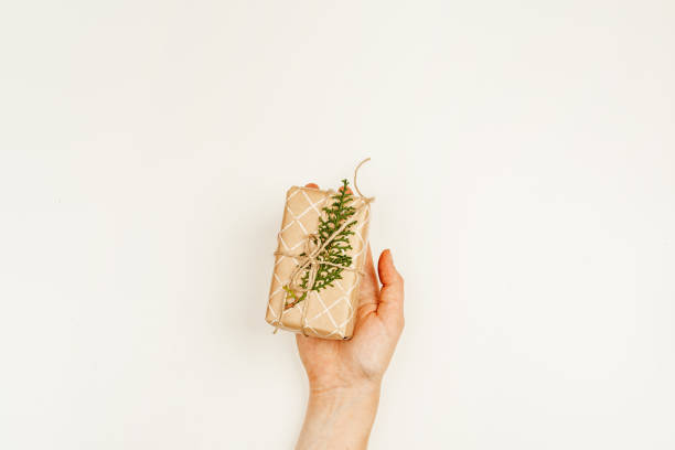 istock Wrapped Christmas gift in woman hands above white background 1343558749