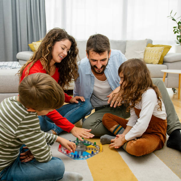 istock Cheerful parents playing board game with their children. 1343558840