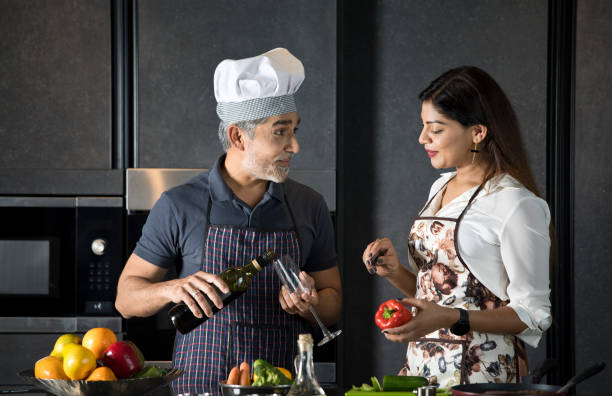 istock Happy couple enjoying champagne while cooking food in kitchen 1343560604