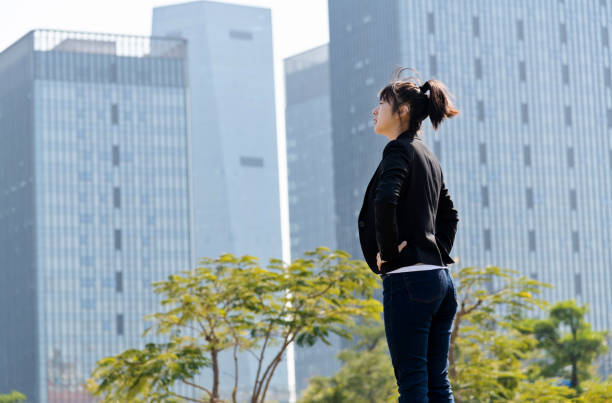 istock Businesswoman standing in front of skyscraper with arms akimbo 1343560607