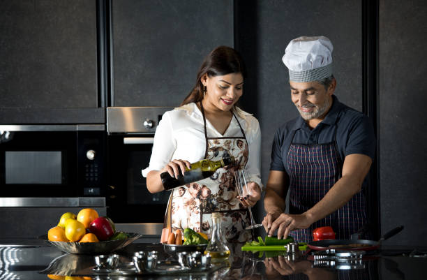 istock Happy couple enjoying champagne while cooking food in kitchen 1343560718