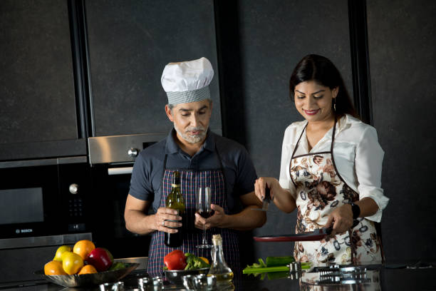 istock Happy couple enjoying champagne while cooking food in kitchen 1343560815
