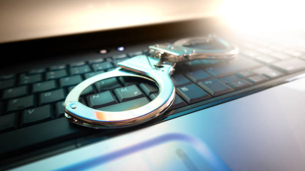 Handcuffs on the laptop Cyber crime, handcuffs on the laptop. Concept for: Internet crime, cyber crime white collar crime handcuffs stock pictures, royalty-free photos & images