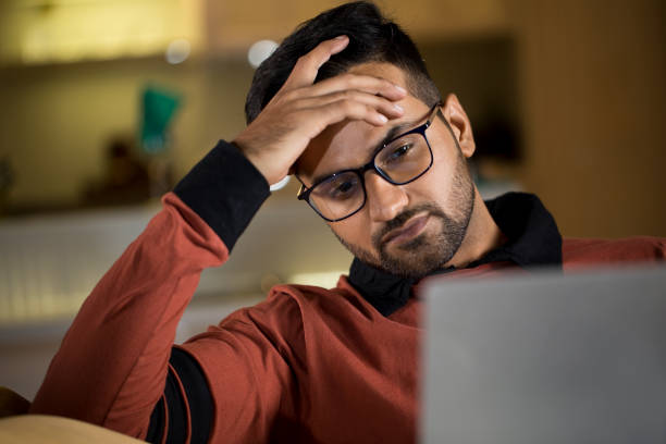 istock Man feeling depressed on receiving bad news using laptop 1343561254