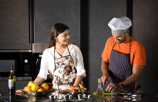 Couple having fun while cooking food in kitchen