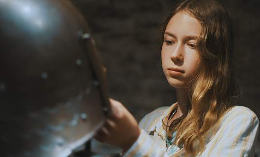 Schoolgirl examines the armor in the museum.