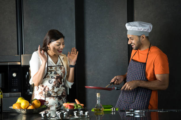 istock Couple having fun while cooking food in kitchen 1343562334