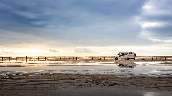 Camper van parked on the beach. Family vacation with caravan. North sea coast, Germany