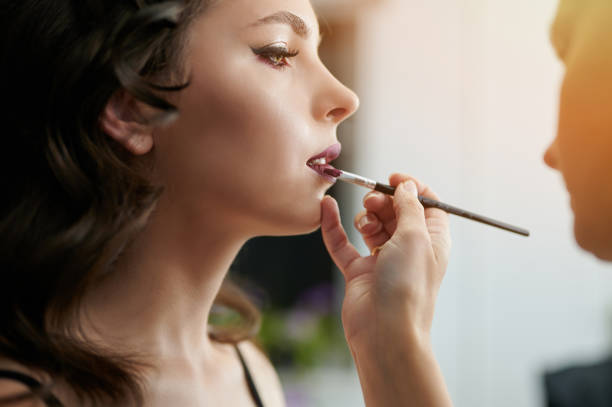 istock Applying lipstick on woman lips 1343564188