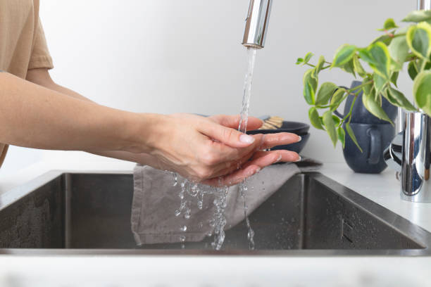 istock Woman washing hands in sink before cooking in kitchen 1343564408