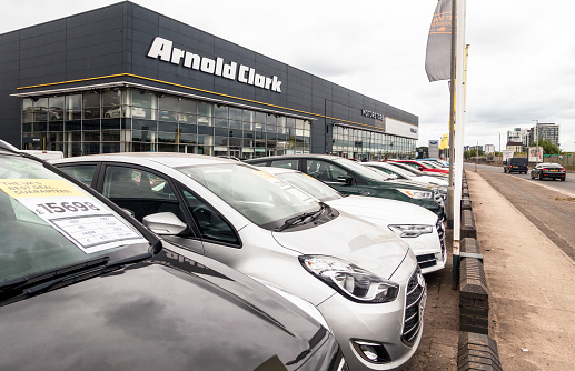 Glasgow, Scotland - Vehicles on the street passing a large Arnold Clark car dealership, with second hand and new cars on sale.